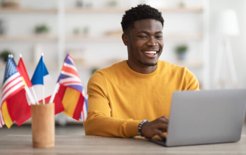 Happy black student studying at language school online