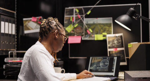 African american private detective studying clues in agency office