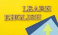 Learn English, words in wooden letters with yellow background