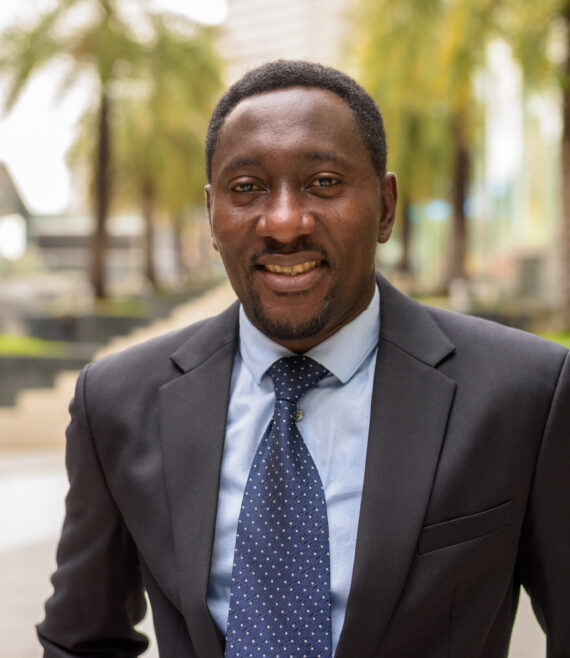 Portrait of handsome African businessman in city smiling