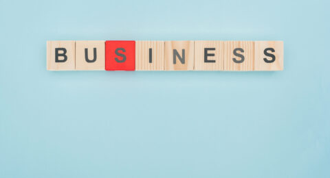 top view of business lettering arranged of wooden cubes on blue background